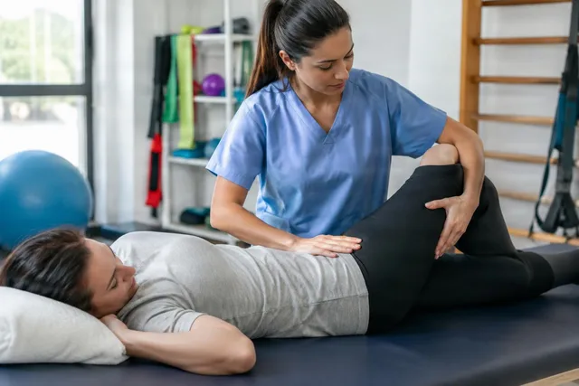 Physiotherapist Mobilizing Patient Hip