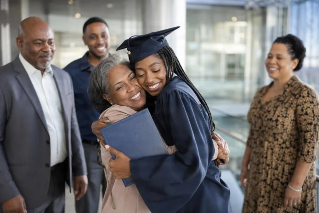 Graduate Hugging Family With Diploma