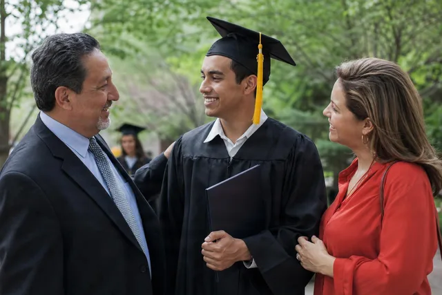 Graduate Celebrates With Parents Outdoors