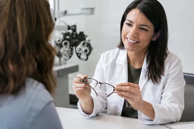Optometrist Presenting Eyeglasses to Patient