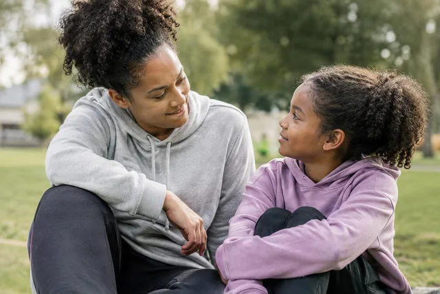 Mother Encouraging Daughter Outdoors