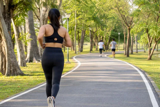 Woman Jogging on Park Path
