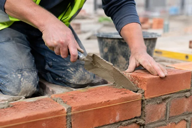 Bricklayer Spreading Mortar Close-Up