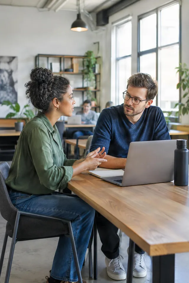 Coworkers Discussing Project at Laptop