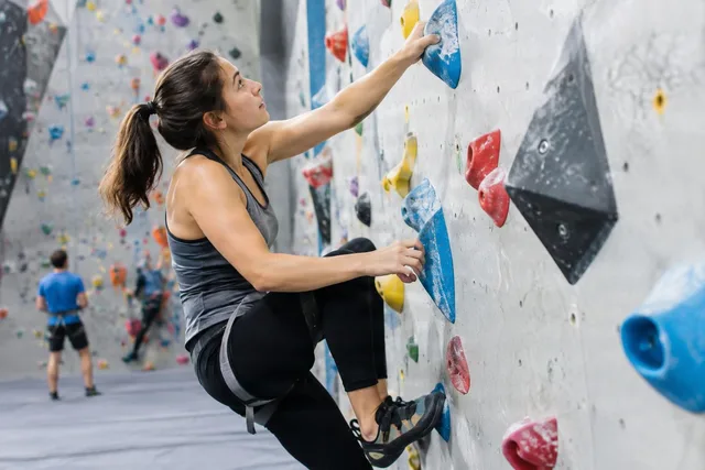 Woman Bouldering Indoors on Holds