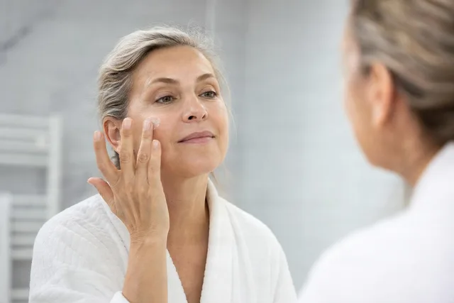 Woman Applying Face Cream Mirror